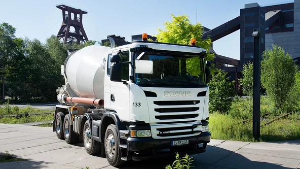 Weißer Betonmischer vor Industrieanlage