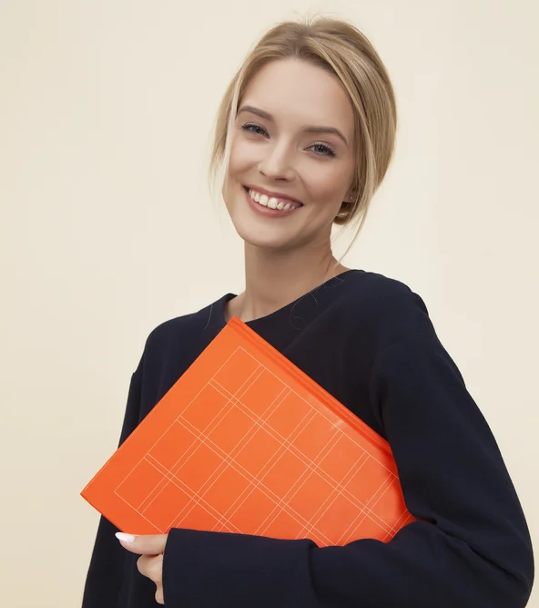 Frau lächelt mit orangefarbenem Ordner in Arm